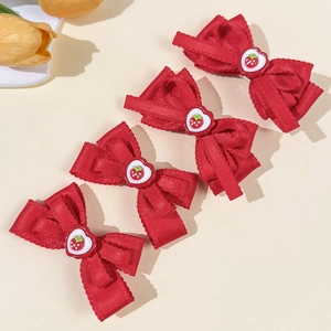 Lot de quatre barrettes nœuds en satin rouge avec breloques fraises et cœurs rouges