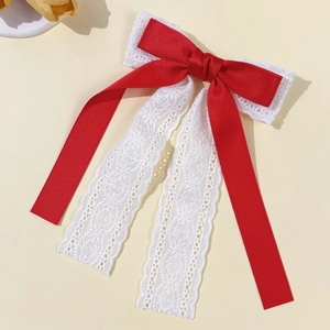 Detail of red silk ribbon and white lace double-layered bow hair clip with long streamers