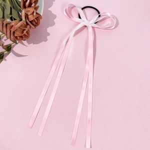 Dettaglio dell'elastico per capelli rosa in seta con fiocco e lunghi nastri fluidi