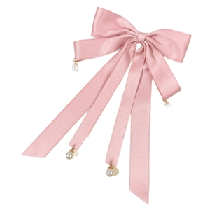 Pink satin bow hair clip with ribbons and white pearl pendants on white background
