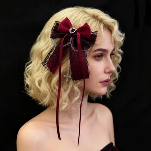 Détail de la pince à cheveux gothique avec chaîne en croix et pierre précieuse en cœur
