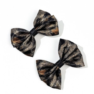 Close-up of leopard pattern bow hair clips with retro golden and bronze woven texture