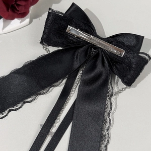 Détail d'une pince à cheveux gothique avec dentelle, chaînes et pendentif croix