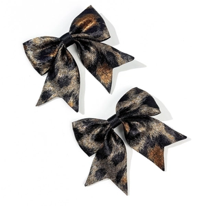 Close-up of leopard print bow hair clips with metallic texture and vintage luxury design