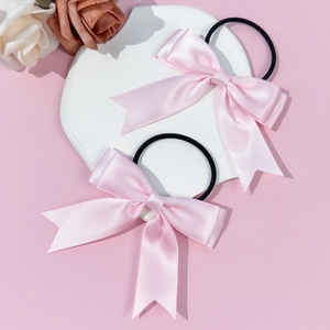 Vue détaillée des nœuds en satin rose avec de longs rubans sur élastiques noirs