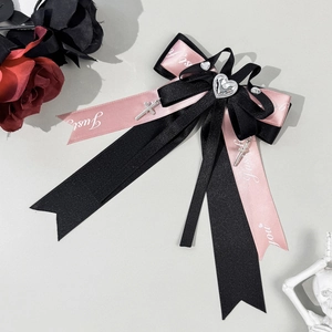 Close-up of pink and black Lolita bow clip with heart rhinestone and cross charms