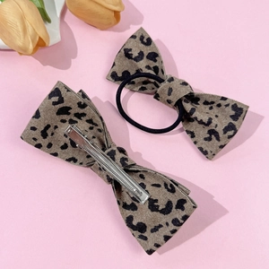 Elegant leopard print bow hair clip and elastic tie set on a minimalist pink background