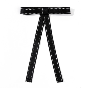 Detail of black bow tie with white contrast stitching on high-density fabric