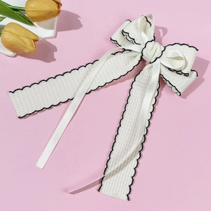 Elegant white waffle fabric bow hair clip with black wavy edges and long satin ribbons