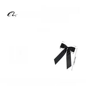 Détails d'un grand nœud en satin noir avec pendentifs étoile et lune argentés