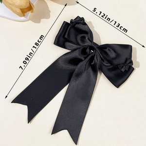 Dettaglio di un fiocco per capelli in raso nero con nastri da 18cm per 13cm