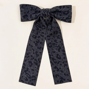 Macro view of leopard print bow hair clip made of high-quality twill textured fabric