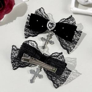 Détail d'une pince à cheveux gothique en dentelle noire avec strass cœur et croix