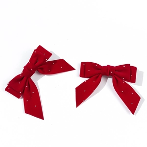 Detail of red velvet bow hair clips with sparkling rhinestones for hair styling