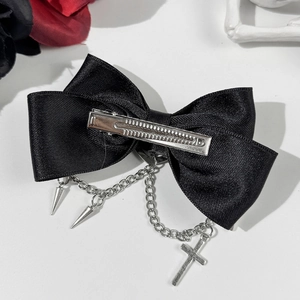Dettaglio di un fermaglio per capelli a fiocco in raso nero gotico con catene e croci
