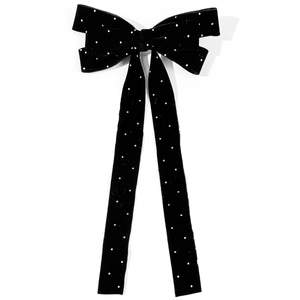 Detail showing high-quality black velvet texture and rhinestones on the bow hair clip