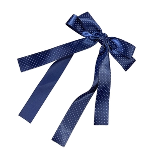 Elegant navy blue polka dot bow hair clip with long ribbons on white background