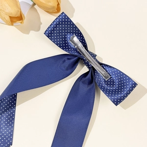 Elegant navy blue polka dot bow hair clip with a secure silver metal duckbill clamp