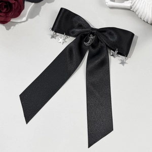 Détail d'un nœud papillon en satin noir avec étoiles argentées et croissant de lune