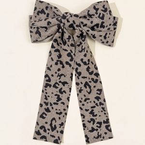 Detail of retro leopard print hair clip featuring long tassel bow in taupe fabric