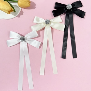 Three elegant satin bow brooches with metal rose centers in white, beige, and black colors