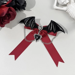 Macro shot of gothic bow hair clip with bat wings and cross heart chain accessory
