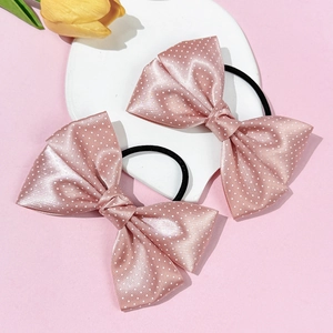 Close-up of pink polka dot satin bow hair ties with elastic bands for sweet daily styling