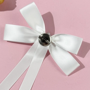 Elegant white satin bow brooch pin with long ribbons on soft pink background