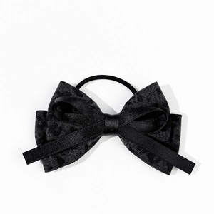 Close-up of black satin bow hair tie with layered velvet texture and elastic band
