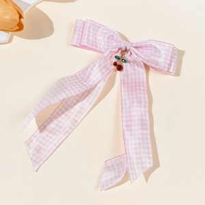 Nahaufnahme der rosa karierten Schleifen-Haarspange mit feinem Kirsch-Anhänger und Strass