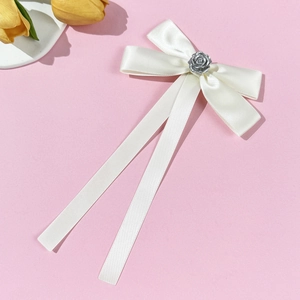 Elegant cream satin bow brooch with long ribbons and a silver rose center accent
