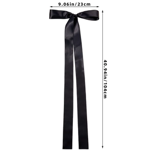 Detail of a large black satin bow hairclip with extra long ribbons and size markings