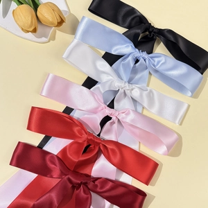 Elegant long silk ribbon bow hair clips in six vibrant colors on a soft yellow surface
