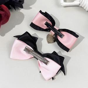 Pink and black Lolita bow hair clips with heart pendant in a gothic aesthetic style