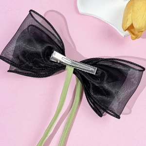 Elegante haarclip met organza strik en groene zijden linten op een roze achtergrond