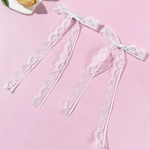 Vue détaillée de nœuds en dentelle blanche avec des motifs floraux et bords ondulés