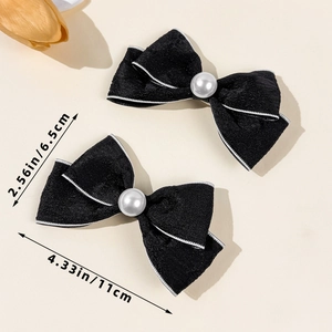 Detail showing dimensions of two black bow hair clips with pearls and white piping detail