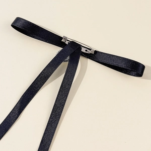 Detailed macro view showing the silver metal safety pin on the black silk bowtie back