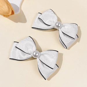 Elegant pair of white jacquard bow hair clips with pearls and black contrast edges