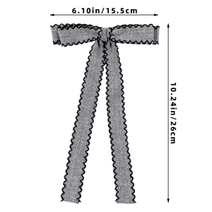 Detail showing grey denim texture bow hair clip with black wavy quilted stitching details