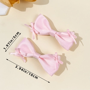 Detailed size view of two-piece set pink satin bow hair clips on warm beige background