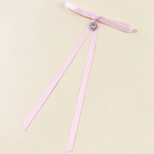Close-up of pink silk bow accessory with heart crystal pendant for women shirts