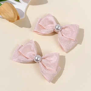Set of two pink silk bow hair clips with central white pearl accents for women