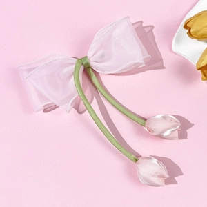 Detailopname van roze tulpenhaarklem met elegante vloeiende groene linten