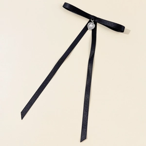Detail of black satin bow choker featuring a sparkling crystal heart pendant decoration