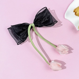 Detail van elegante zwarte organza haarspeld met groene linten en tulpenbloemen