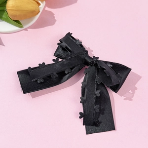 Barrette nœud double en satin noir avec motifs cœurs sur fond rose élégant