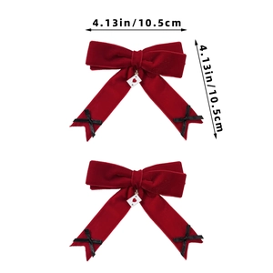 Detail of red velvet bow hair clips with heart poker charm and black ribbon accents