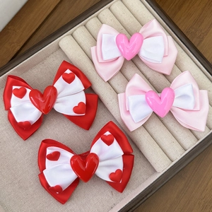 Sweet pink and red heart bow hair clips set for girls displayed on a velvet tray