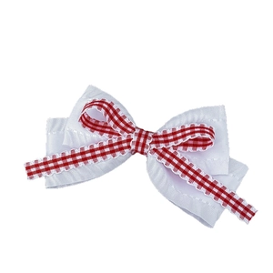 Barrette à cheveux avec nœud à carreaux rouges et dentelle blanche sur fond blanc pur